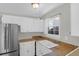 Bright kitchen features white cabinets, stainless steel refrigerator, and view from the window at 867 Colony Dr # F-82, Charleston, SC 29407