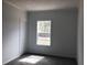 A bright bedroom with a neutral color palette and a large window offering natural light at 8833 Cottageville Hwy, Cottageville, SC 29435