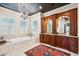 Luxurious bathroom featuring a soaking tub, chandelier, and custom cherry wood cabinetry with granite counters at 935 Royall Ave, Mount Pleasant, SC 29464