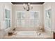 Bright bathroom with soaking tub, white shutters, and elegant chandelier at 935 Royall Ave, Mount Pleasant, SC 29464