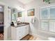 Bathroom vanity with dark countertop, decorative mirror, artwork and natural light at 935 Royall Ave, Mount Pleasant, SC 29464