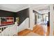 Hallway with hardwood floors, white trim, dark gray walls, and decorative artwork at 935 Royall Ave, Mount Pleasant, SC 29464