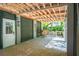 Covered outdoor space featuring a brick floor, wooden beams, and a white entry door at 935 Royall Ave, Mount Pleasant, SC 29464