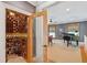 Wine cellar with custom shelving and a glass door, adjacent to an office with a grand piano at 935 Royall Ave, Mount Pleasant, SC 29464