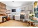 Efficient kitchen design with exposed brick, stainless steel appliances, and a cozy dining area at 1 Percy St, Charleston, SC 29403