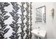 Stylish powder room featuring black and white patterned wallpaper, a modern sink, and a decorative mirror at 1 Percy St, Charleston, SC 29403