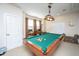 Bright game room with a wooden pool table under an ornate vintage light fixture, seating, and neutral walls at 101 Back Creek Ct, Summerville, SC 29485