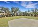 A backyard with a concrete patio surrounded by lush green lawn, trees, and a black metal fence at 1028 Island Preserve Rd, Johns Island, SC 29455