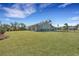 A spacious backyard with a well-maintained lawn, a modern gray home, a patio, and a secure black fence at 1028 Island Preserve Rd, Johns Island, SC 29455