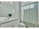 A bright bathroom features a shower with a patterned curtain, white vanity and a toilet at 1028 Island Preserve Rd, Johns Island, SC 29455