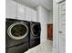 A modern laundry room with front-load washer and dryer and overhead cabinets at 1028 Island Preserve Rd, Johns Island, SC 29455
