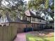 Backyard view featuring patio, mature trees, and Tudor-style accents on home at 104 Legend Oaks Way, Summerville, SC 29485