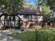Charming Tudor-style home with a well-manicured front yard and mature trees at 104 Legend Oaks Way, Summerville, SC 29485