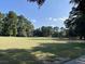 Scenic golf course view with lush green grass and mature trees under a clear blue sky at 104 Legend Oaks Way, Summerville, SC 29485