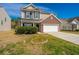 Two-story home featuring a brick facade, attached two-car garage, and well-maintained lawn on a sunny day at 104 Mayfield Dr, Goose Creek, SC 29445