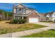 Two-story home featuring a brick facade, attached two-car garage, and well-maintained lawn on a sunny day at 104 Mayfield Dr, Goose Creek, SC 29445