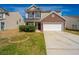 Two-story home featuring a brick facade, attached two-car garage, and well-maintained lawn on a sunny day at 104 Mayfield Dr, Goose Creek, SC 29445