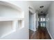 Bright hallway with hardwood floors, built-in shelving, and open doorway, providing a warm and inviting entrance at 104 Mayfield Dr, Goose Creek, SC 29445