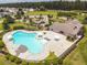 Aerial view of a community pool with lounge chairs, umbrellas, and a clubhouse nearby at 104 Mayfield Dr, Goose Creek, SC 29445
