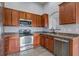 Well-lit kitchen features stainless steel appliances, dark wood cabinetry and tile flooring at 109 Charlesfort Way, Moncks Corner, SC 29461