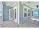 Outdoor space has wood plank flooring, ceiling fan, and exterior view of aqua colored house at 1118 John Mcenery Rd, Charleston, SC 29412