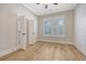 Bright bedroom with light hardwood floors, shiplap accent wall, and large window with plantation shutters at 1118 John Mcenery Rd, Charleston, SC 29412