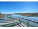 Picturesque waterfront view from a wooden dock with bench seating overlooking the tranquil waterway and distant trees at 1118 John Mcenery Rd, Charleston, SC 29412