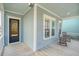 Cozy front porch featuring rocking chairs, light blue siding, and a glass-paneled front door at 1118 John Mcenery Rd, Charleston, SC 29412