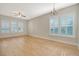 Spacious living room with hardwood floors, ample natural light from shuttered windows, and stylish ceiling fan and chandelier at 1118 John Mcenery Rd, Charleston, SC 29412