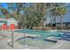 Inviting community pool area with a spa, surrounded by trees, lounge chairs, and a red-doored pool house at 1118 John Mcenery Rd, Charleston, SC 29412
