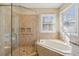 Bathroom with a glass enclosed shower and jacuzzi tub under a window at 1217 Bamboo Dr, Charleston, SC 29407