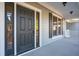 Close-up of the front door with sidelights, dark shutters, and covered porch at 1217 Bamboo Dr, Charleston, SC 29407
