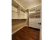 Walk-in closet with built-in white shelving and drawers in a neutral color at 1217 Bamboo Dr, Charleston, SC 29407