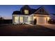 Charming two-story home featuring a stone facade, covered porch with rocking chairs, and an attached two-car garage at 123 Lakelyn Rd, Moncks Corner, SC 29461