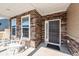 Inviting front porch with stone accents, rocking chairs, and a stylish front door at 123 Lakelyn Rd, Moncks Corner, SC 29461