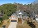 Stunning aerial view of a brick home showcasing its roof, attached garage, and surrounding mature trees at 1249 Waterfront Dr, Mount Pleasant, SC 29464
