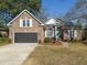 Charming brick home with a two-car garage, manicured lawn, and pleasing architectural detail at 1249 Waterfront Dr, Mount Pleasant, SC 29464