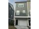Modern townhome featuring a brick-base facade with a one car garage and a light-gray vertically paneled exterior at 1252 Allusion Ln # 201, Mount Pleasant, SC 29466