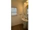 Stylish half bathroom with a pedestal sink, round mirror, and a bright window at 1252 Allusion Ln # 201, Mount Pleasant, SC 29466