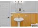 Bathroom features a pedestal sink, wood paneling and modern fixtures at 1288 Old Colony Rd, Mount Pleasant, SC 29464