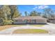Charming single-story home featuring a circular driveway, manicured lawn, and mature trees at 1288 Old Colony Rd, Mount Pleasant, SC 29464