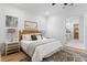 Comfortable bedroom featuring a woven headboard, neutral bedding, wood floors, and an en-suite bathroom at 1328 Upper Union Rd, Mount Pleasant, SC 29464