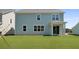 View of the home's light-blue siding, white trim, large windows, and sliding glass door to the backyard at 134 Lilac Grove Way, Summerville, SC 29486