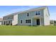 Enjoy the spacious backyard with a lovely light-blue home and a sliding door leading to outdoor living at 134 Lilac Grove Way, Summerville, SC 29486