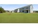 Expansive backyard featuring lush green grass, a charming pale-blue house, and beautiful landscaping at 134 Lilac Grove Way, Summerville, SC 29486