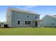 Charming light-blue house with white trim, large windows, and sliding glass doors opening to a spacious backyard at 134 Lilac Grove Way, Summerville, SC 29486