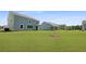 Picture of a vast green backyard with light-blue homes, beautiful landscaping and blue sky at 134 Lilac Grove Way, Summerville, SC 29486