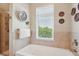 Bright bathroom with a soaking tub, tiled walls and a window offering natural light and privacy at 145 Pier View St # 316, Charleston, SC 29492