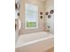 Inviting bathroom featuring a soaking tub with a window view, complemented by decorative wall art at 145 Pier View St # 316, Charleston, SC 29492