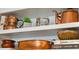 Close-up of decorative items displayed on a shelf, including copper cookware, books, and small plants at 145 Pier View St # 316, Charleston, SC 29492